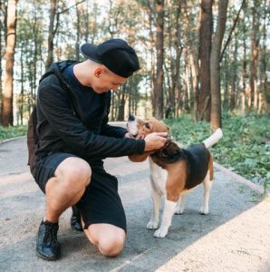 young man with dog on rural road in forest